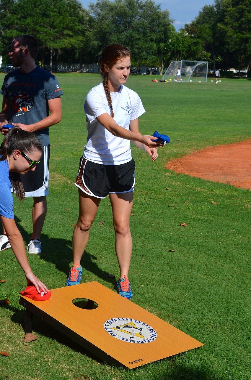 Lauren Solomon focuses on the board during a corn hole game.