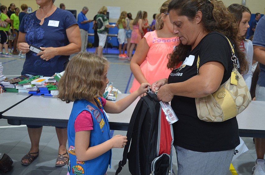 Miriam Lippe helps Hannah Lippe close her full backpack.