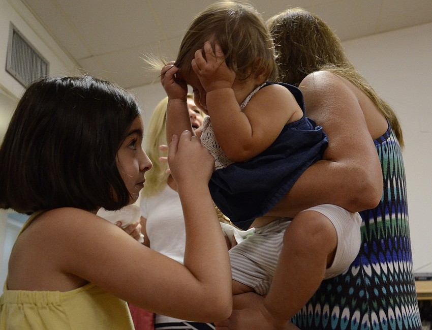 Mia LaPorta, 7, plays with Raquel Vieira, 13 months, during the Temple's 