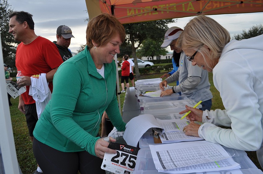 Jennifer McCullen, of Lakewood Ranch, registers for the race with the help of Joan Novak.