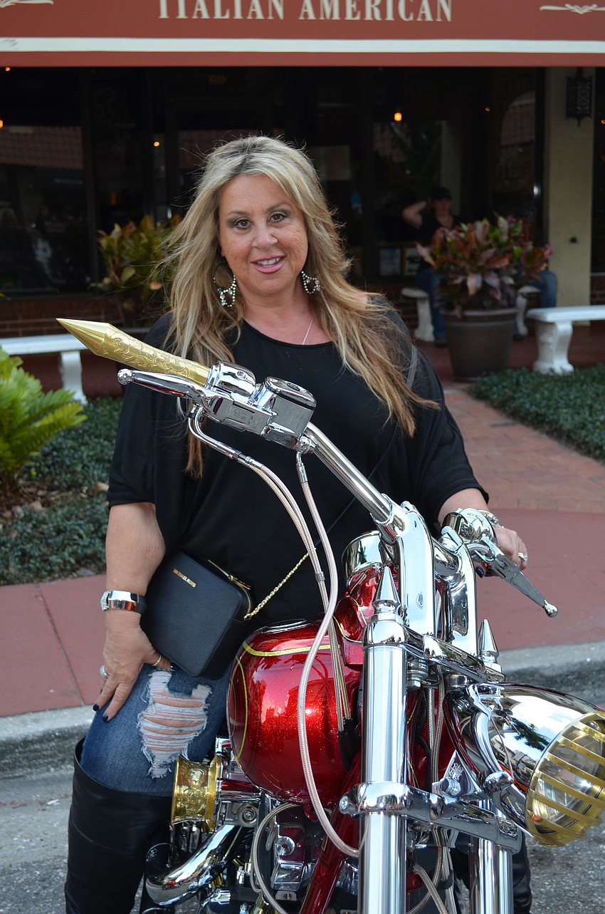 Maria Wolf proudly displays her motorcycle.