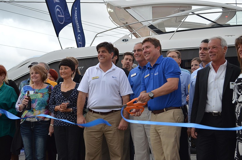 David Bair cuts the ribbon at the Monday Mixer to recognize the remodeled Quality Boats location.