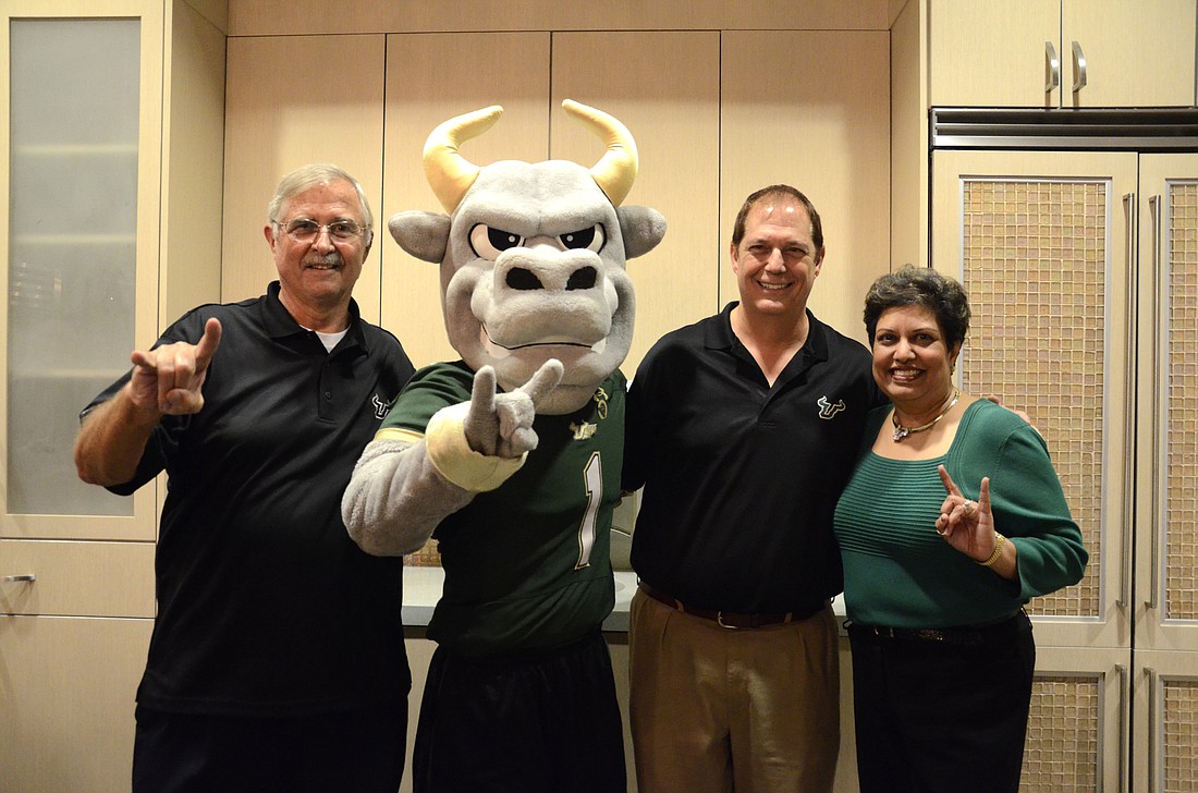 Ted Bogusz, far left, and Anila Jain, far right, organized a graduation party for Bill Mariotti Friday, Dec. 11, at the USFSM Culinary Innovation Lab in Lakewood Ranch. Rocky the bull made an appearance.