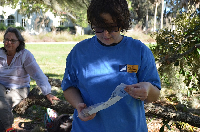 Second year New College student Kriz Brzostek inspects a Quahog or hard-shell clam that was found.