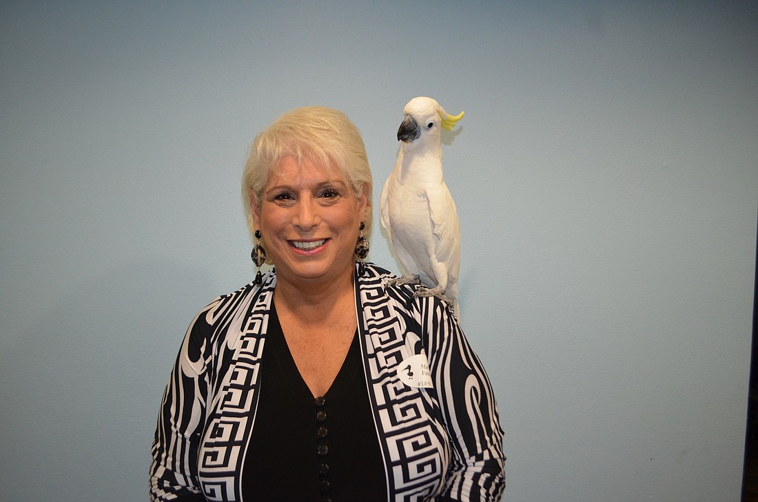 Marsha Panuce with Kelly, a cockatoo, at 2015â€™s Save Our Seabirds Sunset Soiree.