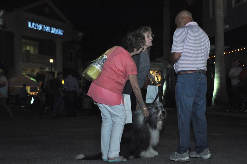 Visitors Kathy Hambel and Carole Fariss pet Cooper, a bearded collie, and talk with his human Don Tauber of University Park.