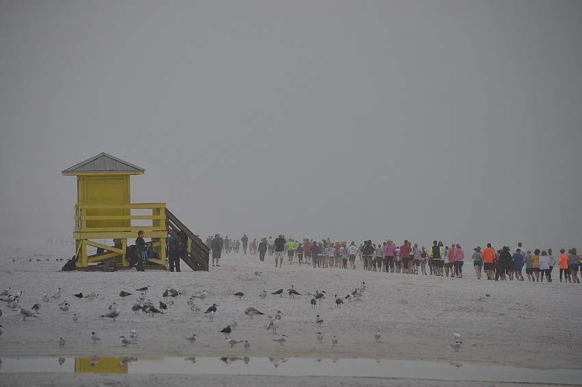 Runners head south through the fog on Siesta Beach for the 3rd annual Andrew Monroe Memorial 5K.
