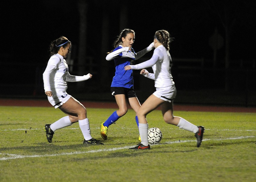 Sarasota Christian's Neah Schlabach attempts to bring the ball down the filed in between a pair of ODA defenders.