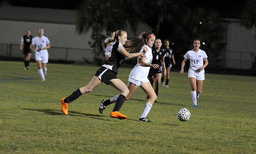 Lakewood Ranch's Alexandra Boudreau pushes the ball past Sarasota's Savannah Jordan.