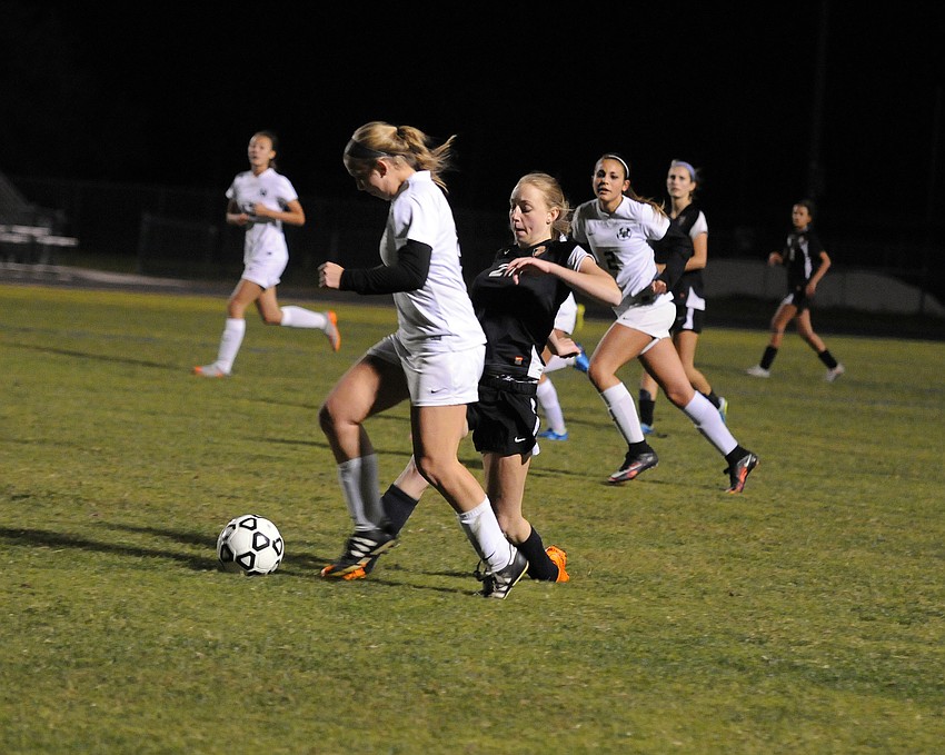 Lakewood Ranch's Sydney Wicks attempts to maneuver the ball past Sarasota's Savannah Jordan.
