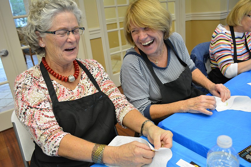 Dani Stanton shares a laugh with Peggy Kearns, after Kearns accidentally dips her paintbrush into her glass of wine.