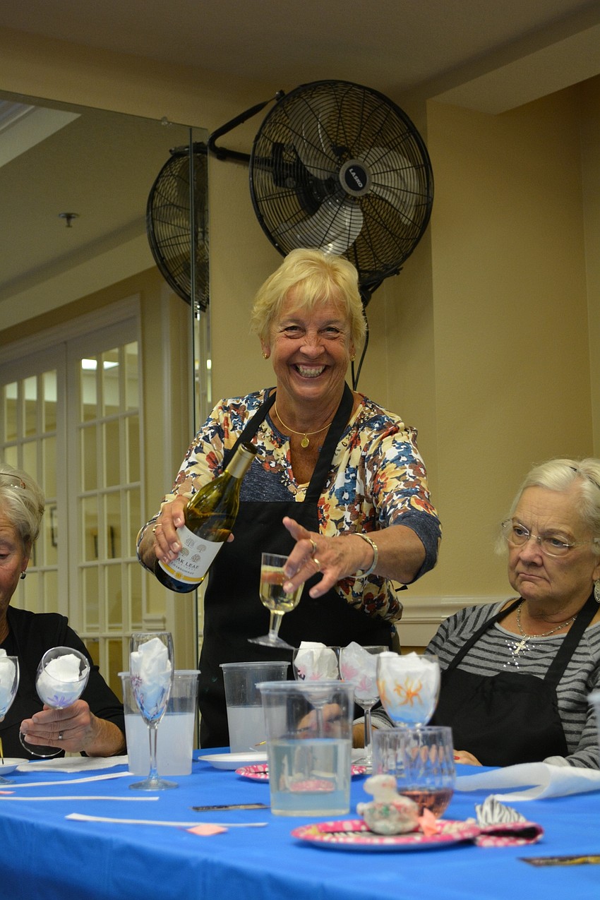 Jan Lane refills glasses of wine.