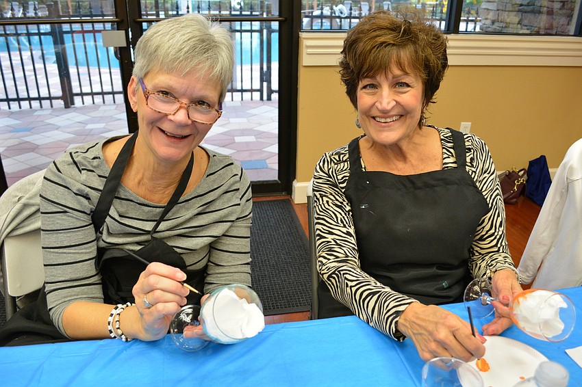 Chris Olson and Paula Buchele catch up while painting.
