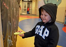 Five-year-old Beau Murphy chalks up construction paper during the event.