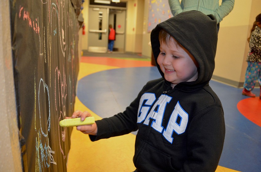 Five-year-old Beau Murphy chalks up construction paper during the event.