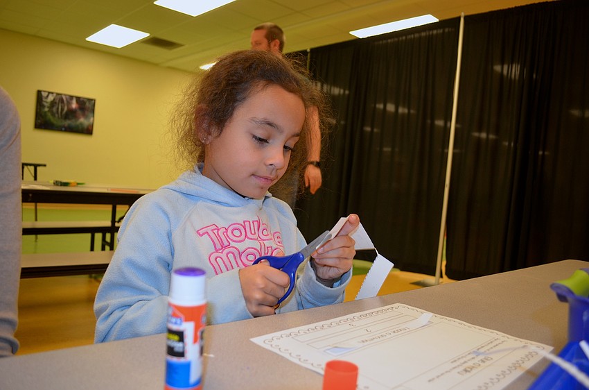 Six-year-old Gabriella Ortega cuts and glues a project to bring home.