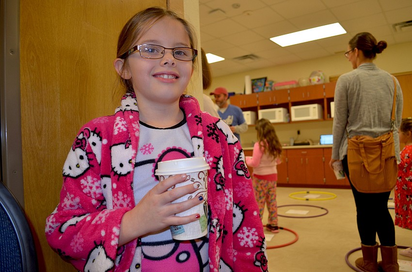 Riley Dotson, 7, enjoys hot cocoa in her pajamas and robe she brought from home.