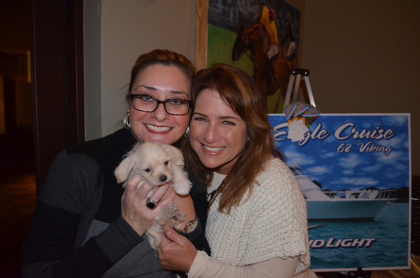 Jessica Ortiz and Jaymie Klauber, chairwomen of the Ponies for Pups event, snuggle up with a new friend.