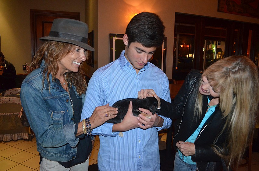 Tammy Wyman and Susie Chinn make two new friends — Tav Ortiz and a mixed-breed puppy.