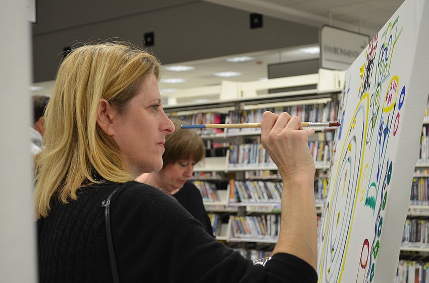 Lauren Gale contributes to a painting during the evening.