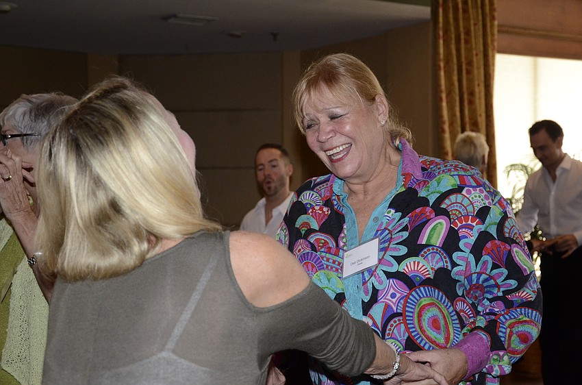 Sharon Crucet and Deb Dickenson laugh after trying to swing their hips during their salsa lesson.