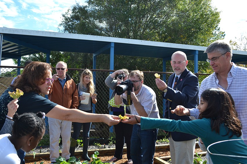 Pine View School teacher Marybeth Torres toasts with a leaf of lettuce.