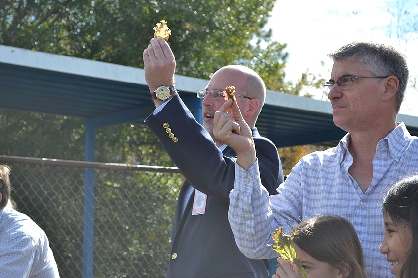 Pine View School Principal Stephen Colvert and chef Paul Mattison toast with lettuce leafs.