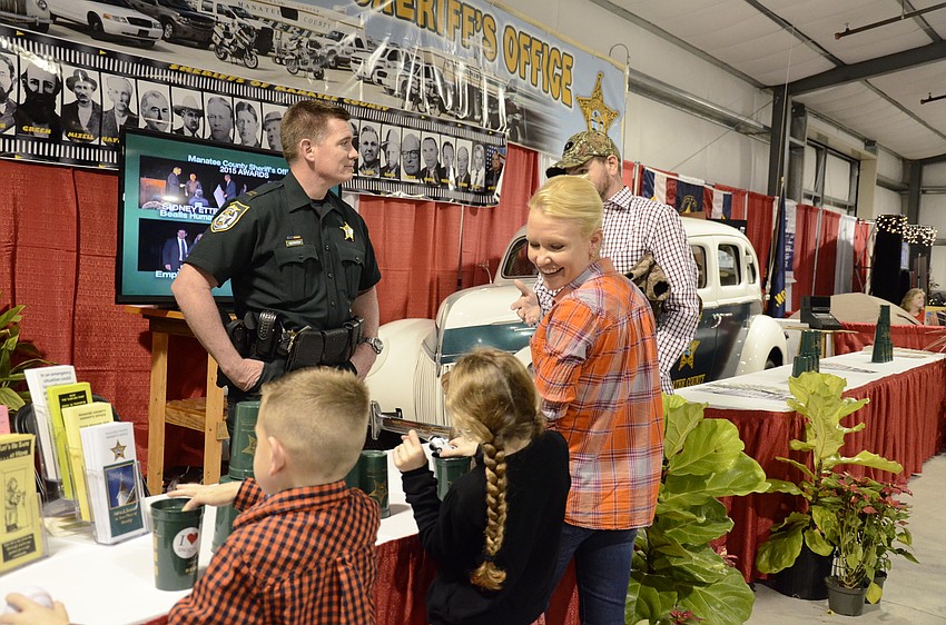 Manatee County Sheriff's Office Captain Rick Gerken talks with Joe Hill of Bradenton, his wife, Angel, and their children Sophie and Eli.