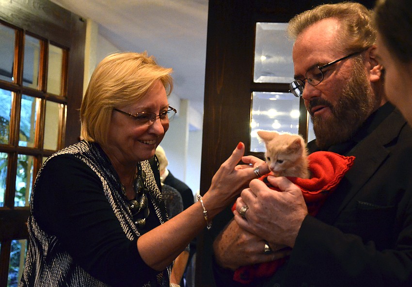 Chris Leis, left, and Randolph Locke pet Tang the kitten.