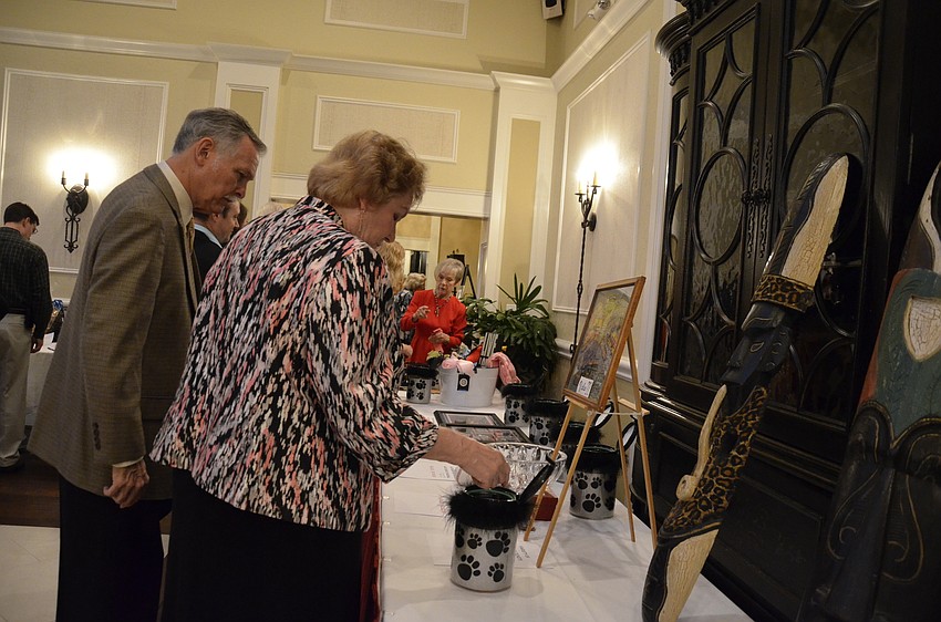 Brinton Smith and Mellonie Smicklas check out the silent auction items. The two Oasis supporters designed the table settings for the event.