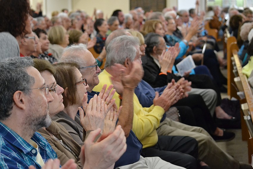Audience members clap along with the performance.