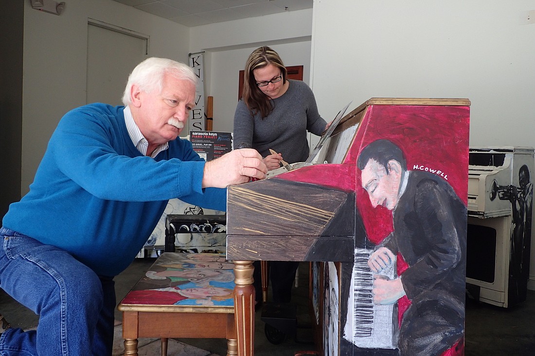Arts and Cultural Alliance Executive Director Jim Shirley and Communications Manager Rachel Denton work to repair one of the pianos that will be on display as part of the Sarasota Keys project.