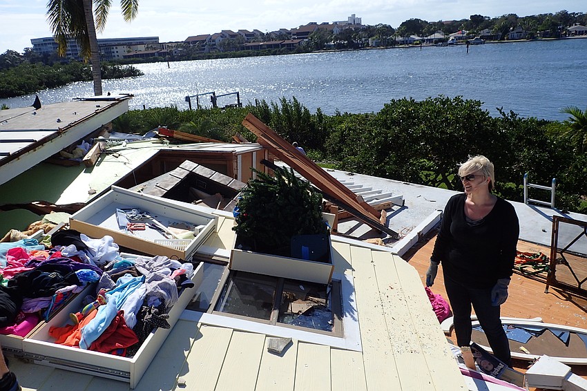 Niki Best helps rescue items from the home of her grandmother, Nancy Devito, who was pinned under the rubble for two hours before rescuers were able to free her.
