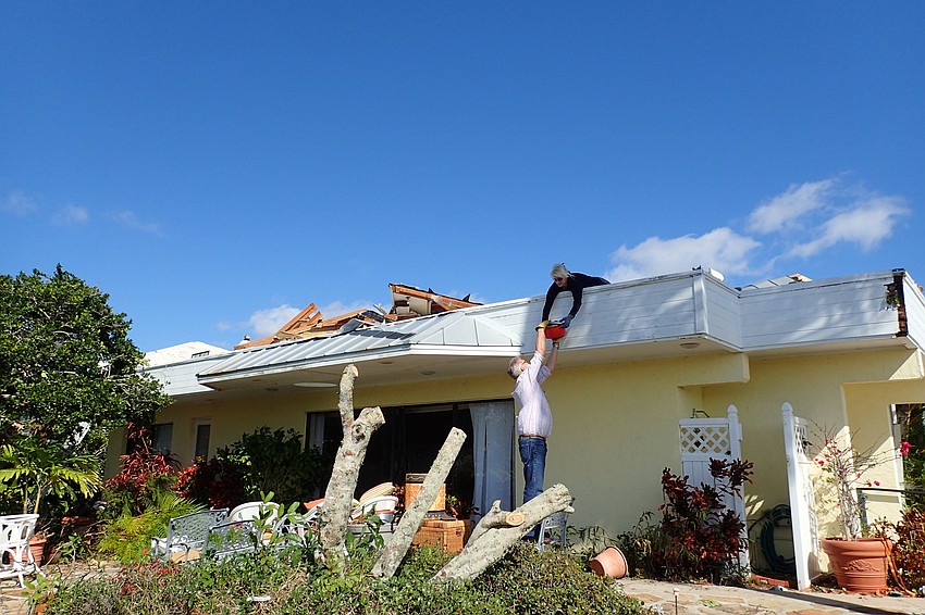 Niki Best and a volunteer  salvage items from the home of her grandmother, Nancy Devito, who was pinned under the rubble for two hours before rescuers were able to free her.