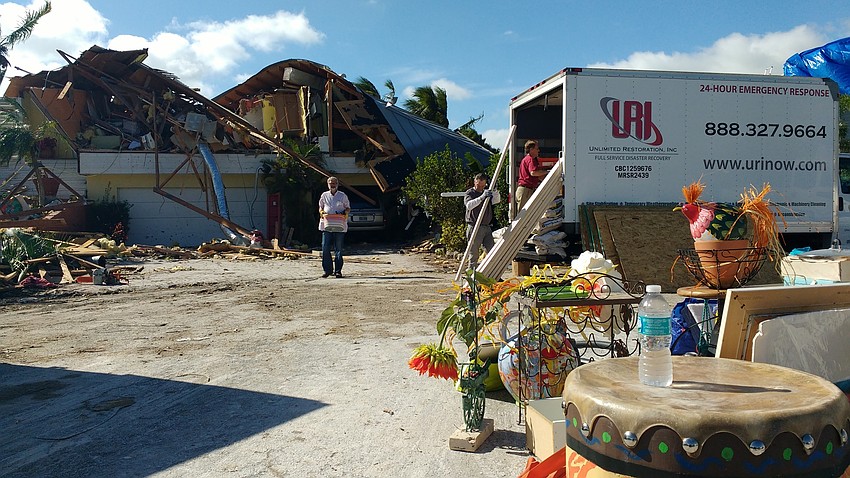 Volunteers  salvage items from the home of  Nancy Devito, who was pinned under the rubble for two hours before rescuers were able to free her.