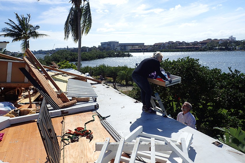 Niki Best and a volunteer  salvage items from the home of her grandmother, Nancy Devito, who was pinned under the rubble for two hours before rescuers were able to free her.