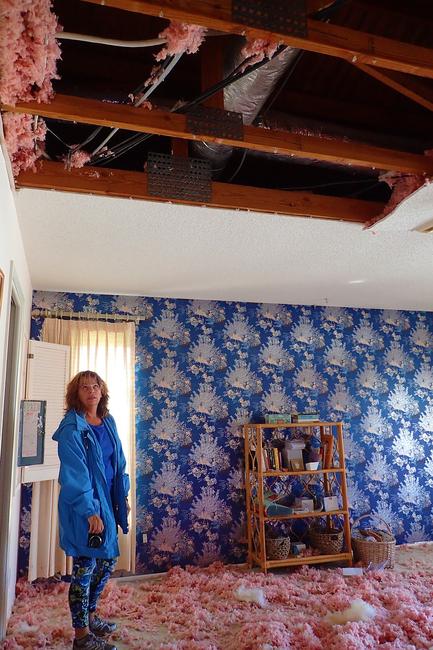 Pauline Vileno looks at the remains of part of her ceiling. She was thankful there was no damage to her bedroom, where she slept as the storm hit.