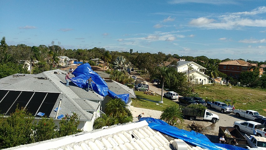 Blue tarps dotted the neighborhood from above, as homeowners worked to prevent water from entering damaged roofs.