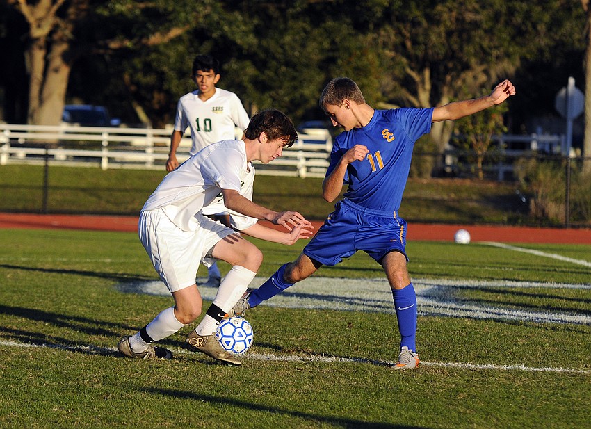 Sarasota Christian's Trey Lantz battles a St. Stephen's midfielder for possession.