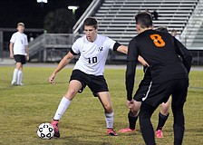 Lakewood Ranch junior defender Tyler Puhalovich attempts to push the ball past Sarasota's Kerrington Anders.