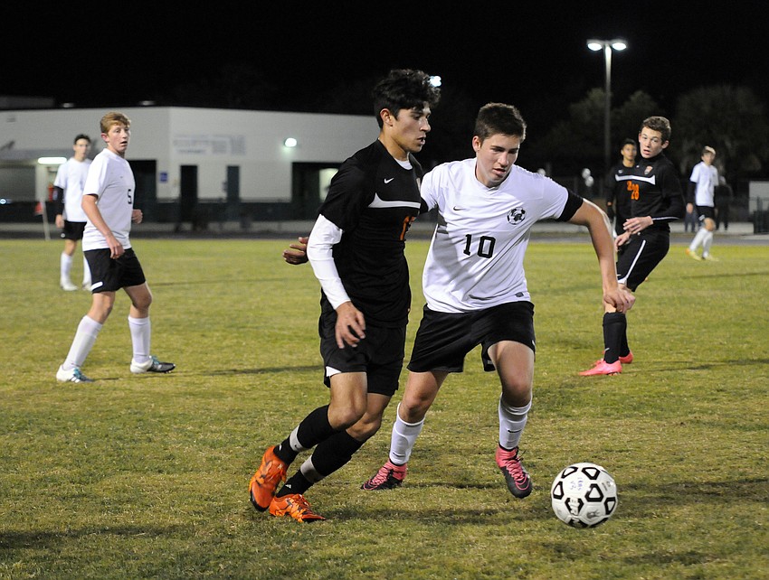 Sarasota's Jivan Rodriguez attempts to send the ball past Lakewood Ranch defender Tyler Puhalovich.