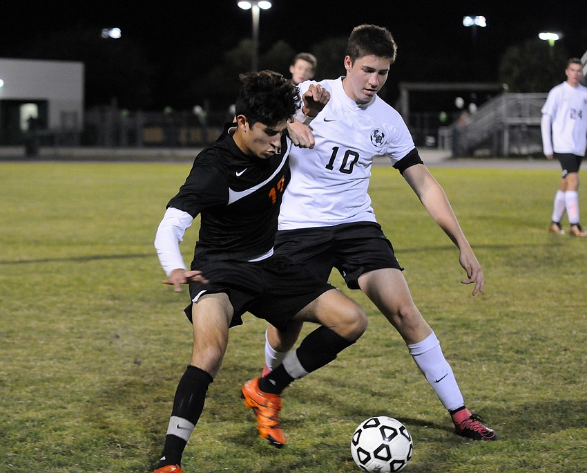 Sarasota's Jivan Rodriguez and Lakewood Ranch's Tyler Puhalovich battle for the ball in the first half.
