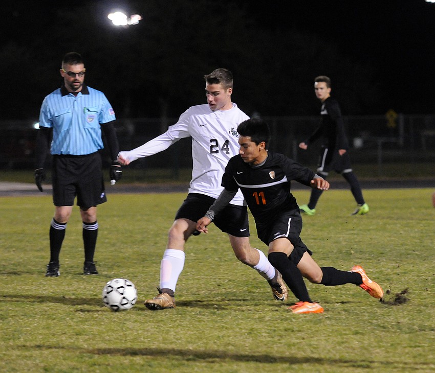 Lakewood Ranch freshman Travis Freeman pushes the ball past Sarasota sophomore Cesar Luna-Hernandez.