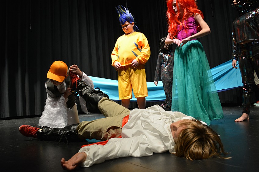 Scuttle (Ryan Newhams), Flounder (Dru Cappar) and Ariel (Alexia King) check to see if Prince Eric (Phineas Scanlon) is alive after he washes up on shore following a storm.