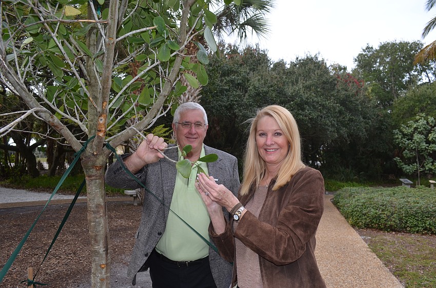 Steve Schield and Garden Club President Susan Phillips sign their names on the tree.