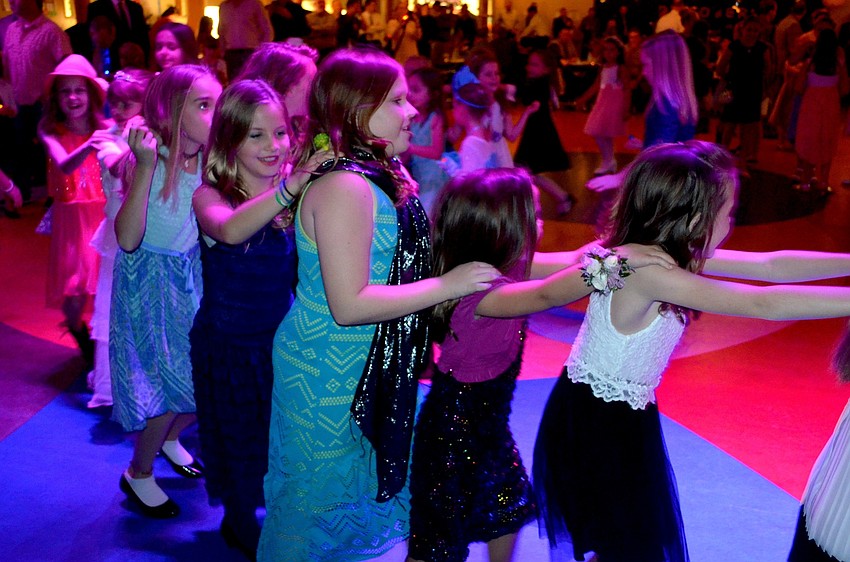Girls of all elementary grade levels make a soul train while dancing to the music.
