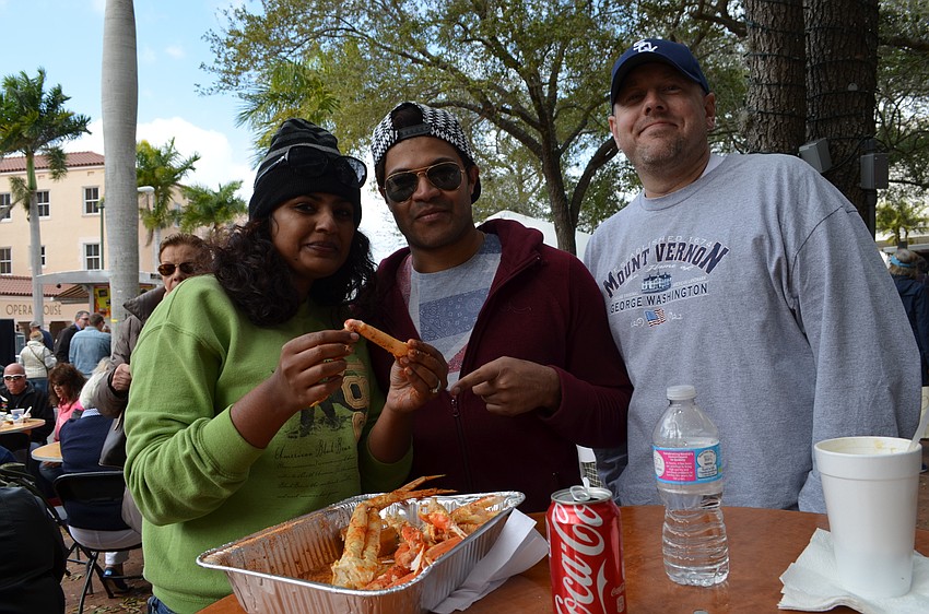 Bhuvvi Howard, Jai Ananda and David Howard enjoy crab legs with spices.
