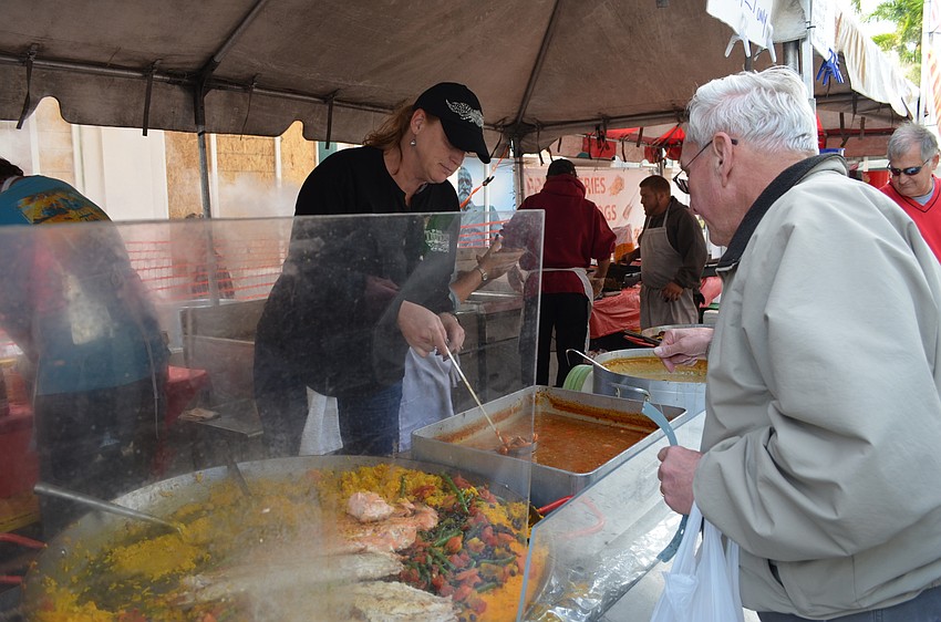 Karen Reynolds serves Don Scarborough a bowl of hot Cajun jambalaya.