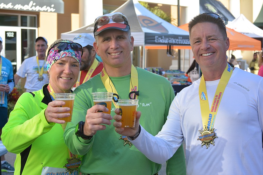 Lois Davis, her husband John Davis and Jason Briggs, all of Lakewood Ranch, enjoy a well-deserved beer after the finish. Lois Davis and Briggs ran 2:05s, while John Davis set a personal best at 1:43.