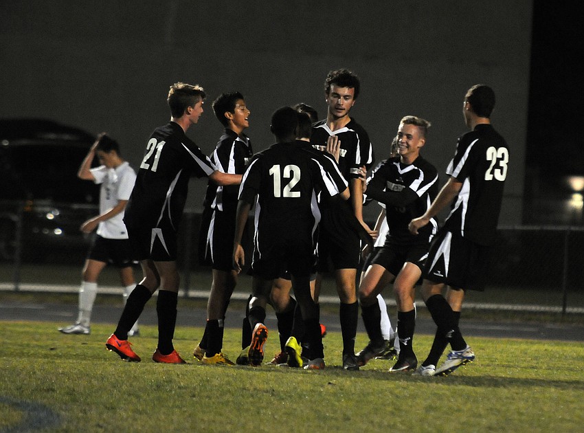 The Riverview High boys soccer team celebrates following senior Etienne Behan's goal in the first half.